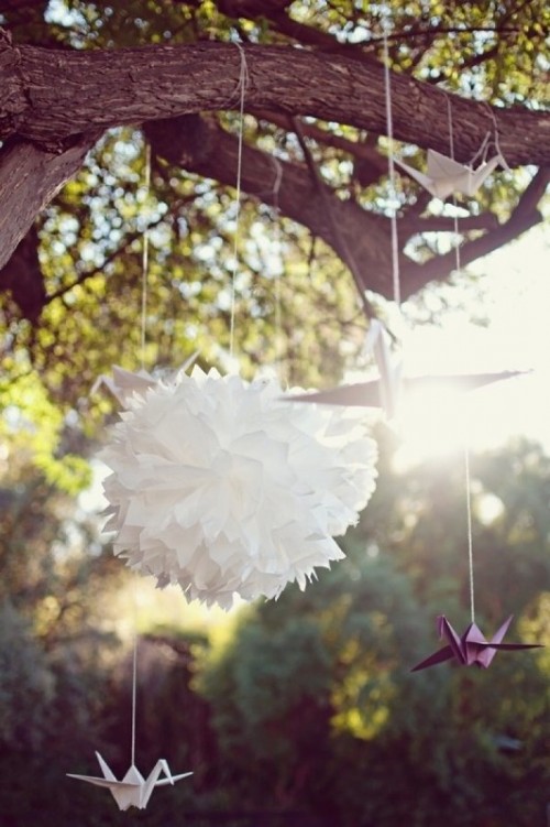 origami cranes and paper pompoms can be hung in your wedding ceremony space or a reception one for decorating