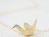 a gold necklace with an origami crane pendant is a lovely idea for wearing at a wedding or to give as a bridesmaid favor