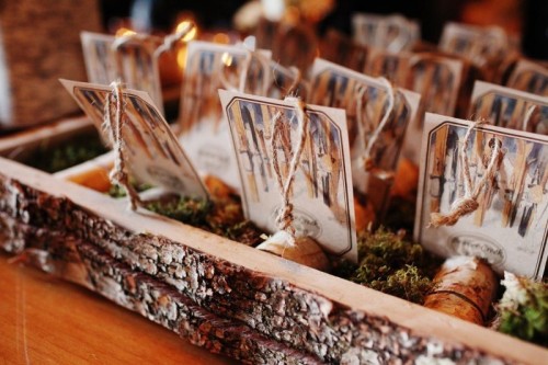 a wedding seating chart done of a bark box with moss, wood pieces and birch bark cards