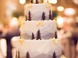 a gorgeous mountain wedding cake with little trees, blooms and petals is a cool way to embrace the location
