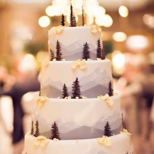 a gorgeous mountain wedding cake with little trees, blooms and petals is a cool way to embrace the location