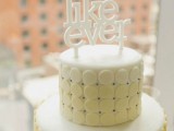 a creative modern wedding cake with yellow discs and with an ombre effect plus a white cake topper is a fun idea