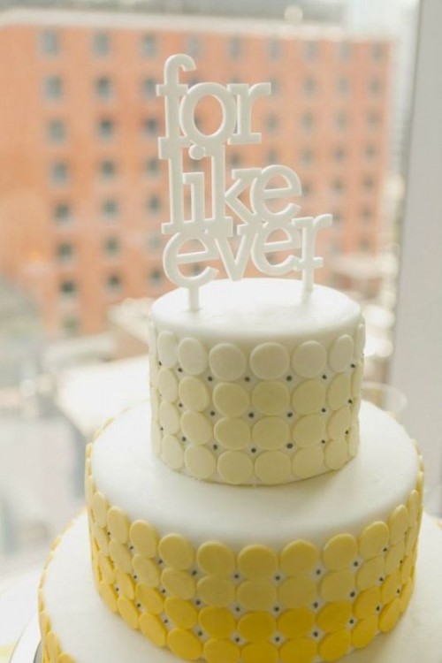 a creative modern wedding cake with yellow discs and with an ombre effect plus a white cake topper is a fun idea