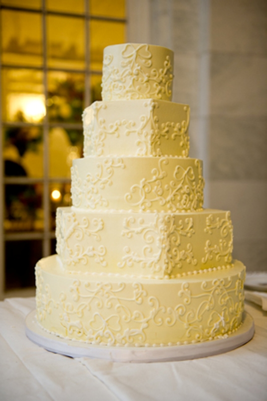 A yellow patterned wedding cake with sugar beads is a traditional and elegant wedding dessert