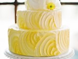 an ombre white to yellow textural wedding cake with a white bloom is a fun idea for a spring or summer wedding