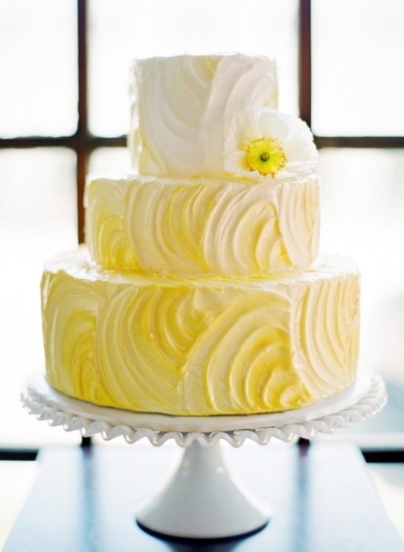 An ombre white to yellow textural wedding cake with a white bloom is a fun idea for a spring or summer wedding