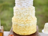 a whimsical and cute ombre ruffled wedding cake with lemons on top for a vintage-inspired wedding