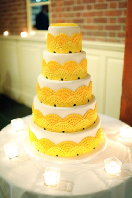 a bright and fun wedding cake in white, with yellow ruffle fans is a cool idea for a bright summer wedding