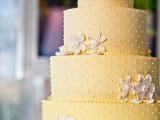 a yellow polka dot wedding cake with sugar blooms is a very cool and elegant idea for a bold spring or summer wedding