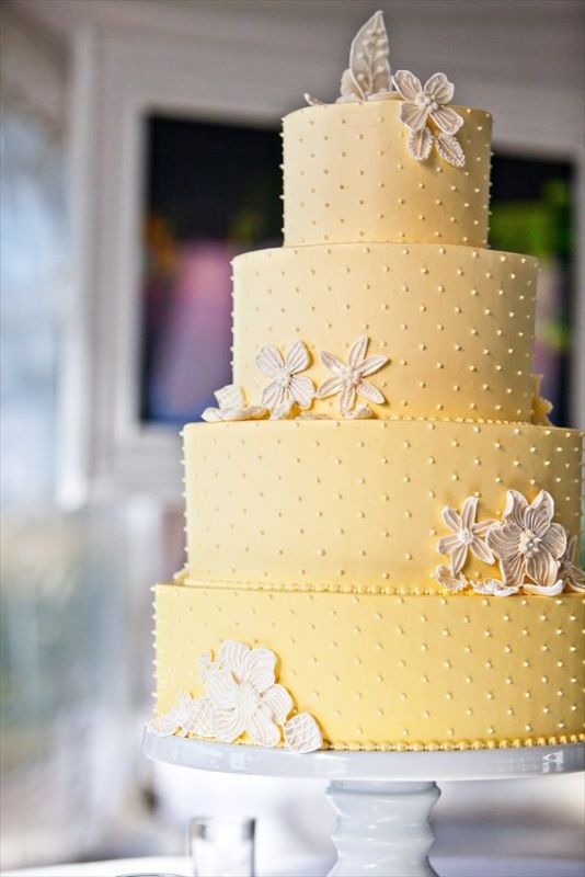 A yellow polka dot wedding cake with sugar blooms is a very cool and elegant idea for a bold spring or summer wedding