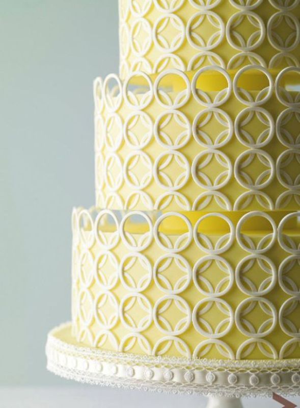 A yellow wedding cake with white sugar rings is a bold idea for a mid century modern wedding