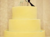 a yellow plain wedding cake with mini birds on top is a stylsh colorful idea to rock