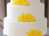 a white wedding cake with yellow sugar blooms and rhinestones is a bold and playful idea for a modern bright wedding