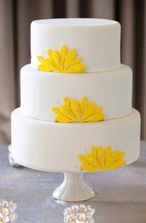 a white wedding cake with yellow sugar blooms and rhinestones is a bold and playful idea for a modern bright wedding