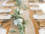 a simple wedding table runner of olive foliage and white blooms plus a burlap runner to pair it with are a cool rustic combo