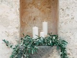 a niche decorated with olive greenery and pillar candles will give a refined yet natural feel to your space