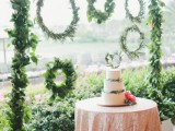 a greenery arch and an arrangement of wreaths of olive foliage and some leaves looks bold and beautiful