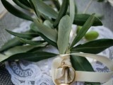 a porcelain plate with a lace doily and some olive branches to hold the rings is a cool idea for a natural wedding