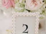 a chic and glam wedding table number in a pearl frame is a cool idea to accent your table