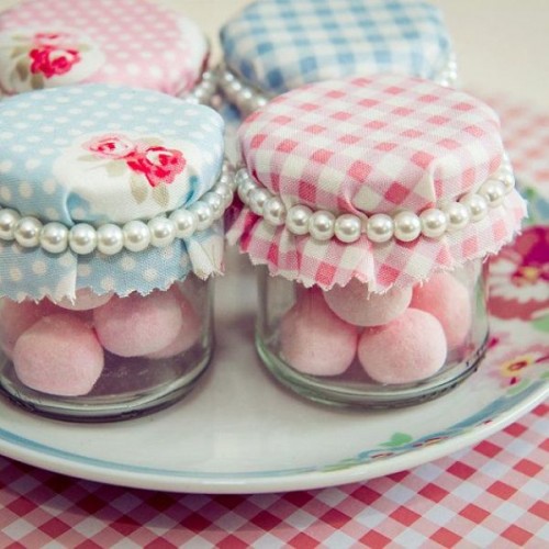 homemade pink cookies in jars covered with floral and plaid fabric and pearl ties look cute, chic and vintage-like