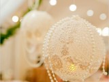 doily pendant lanterns with pearls hanging on them are a cool idea to light up your venue with glam and chic