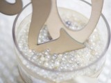 a glass filled with pearls and beads and with table numbers is a cool idea for decorating your table