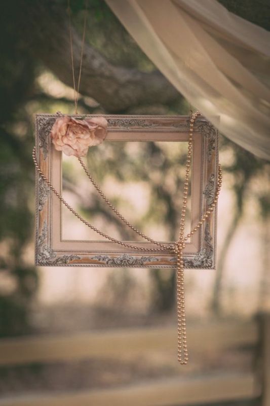 A refined frame with a pink flower and strands of pearls to make chic vintage inspired photos