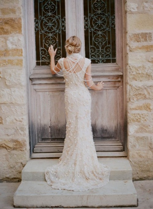 a lace applique A-line wedding dress with an open back and lots of strands of pearls to look wow