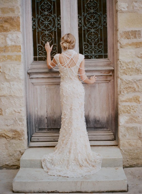 A lace applique A line wedding dress with an open back and lots of strands of pearls to look wow