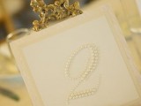 a refined wedding table number with pearls and decorated with gold is chic, bold and stylish