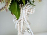a neutral bouquet wrap with rhinestones and strands of pearls is a cool and chic idea to look refined