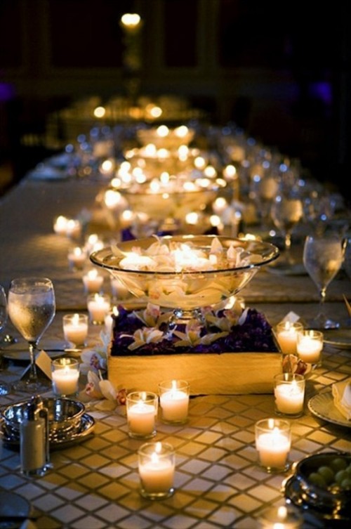 candles and large glass bowls with floating candles will create a romantic and cozy feel at the reception and will welcome your guests