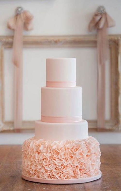 a light pink wedding cake with sleek tiers and a ruffle one, with ribbons is a very elegant and glam idea for any glam wedding