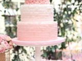 a light pink wedding cake with two ombre tiers, with a pink floral tier, gold monogram toppers is a gorgeous idea for a wedding