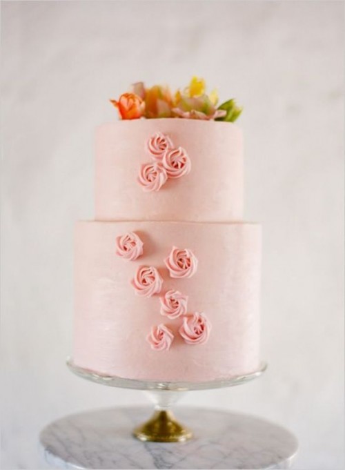 a light pink wedding cake with pink meringues, bright blooms on top is a very cool idea for any bright wedding
