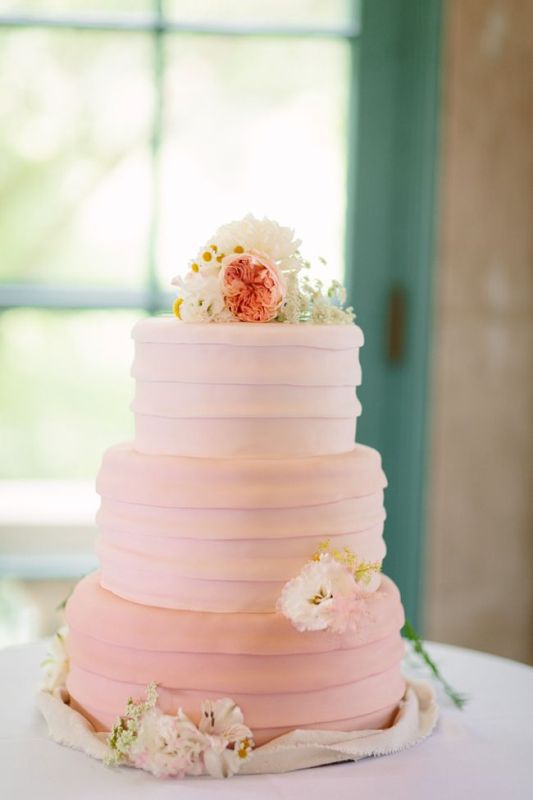 A pink textural buttercream wedding cake with white and pink blooms on top is a pretty and lovely idea for a spring or summer rustic wedding