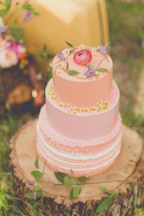 a delicate pink summer wedding cake with some wildflowers on top is a fantastic boho or wildflower wedding idea