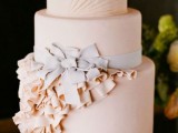 a refined blush buttercream wedding cake with stripes, with sugar ruffles and a grey sugar bow is amazing