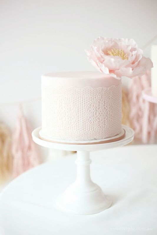 A blush wedding cake with a lace cover and a light pink bloom is a gorgeous idea of a dessert, refined, chic and vintage inspired