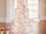 a shiny pink multi-tier wedding cake with white sugar and usual blooms is a fantastic idea for a spring or summer wedding in a delicate shade