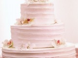 a very simple pink striped buttercream wedding cake topped with orchids is a cool idea for a tropical wedding, and the delicate color contrasts the blooms
