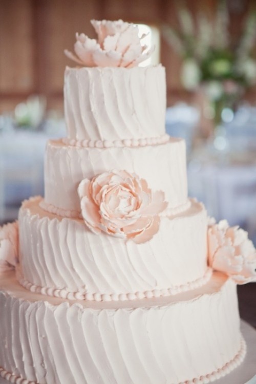 a textural blush buttercream wedding cake decorated with blush sugar blooms looks very beautiful and very delicate and will match a refined wedding