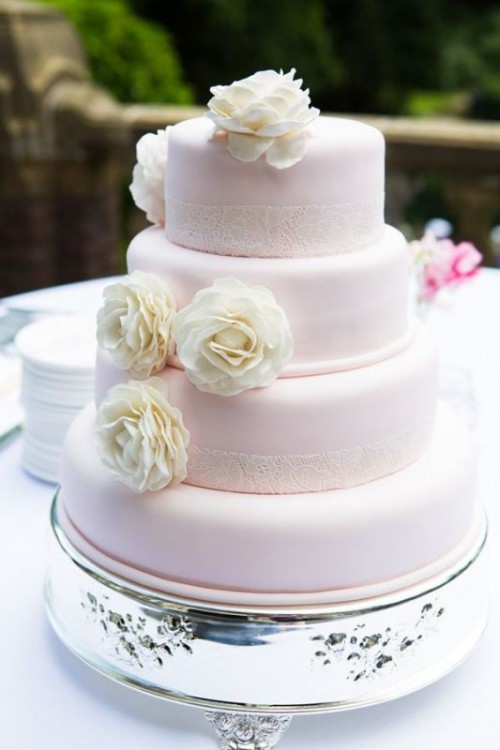 a light pink buttercream wedding cake with white doilies and white blooms looks like an amazing option for a summer wedding with blush touches