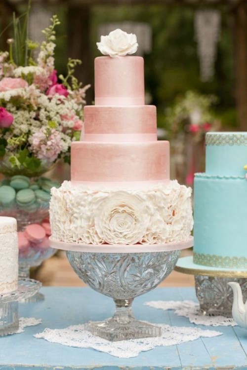 a shiny pink wedding cake with a white ruffle flower tier, a white sugar flower on top is a gorgeous idea for your wedding