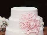 a light pink wedding cake with an oversized pink sugar bloom for decor is a gorgeous idea for a tender and cute spring wedding