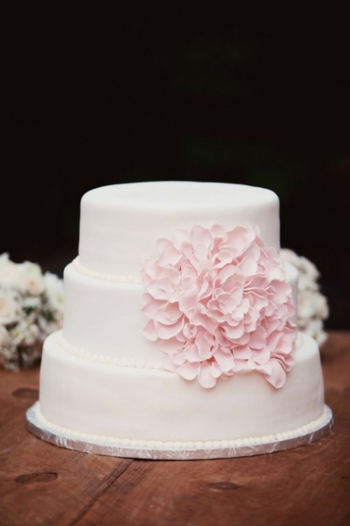 a light pink wedding cake with an oversized pink sugar bloom for decor is a gorgeous idea for a tender and cute spring wedding