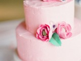 a light pink textural buttercream wedding cake with pink sugar flowers and a leaf is a colorful and cheerful idea for a summer wedding