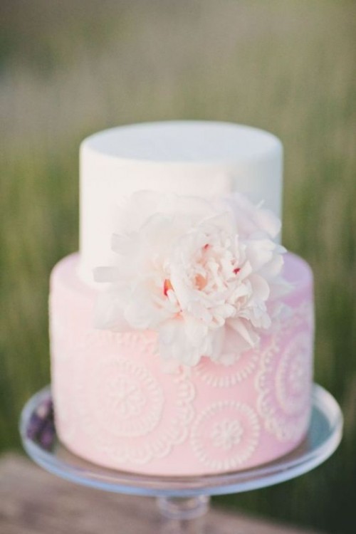 a beautiful light pink and white patterned wedding cake with a large white bloom is a very eye-catchy and stylish idea for a romantic wedding