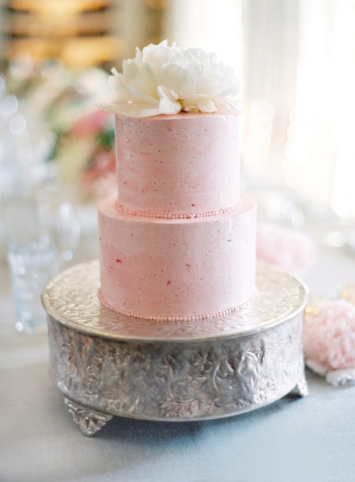 a textural pink wedding cake topped with a large white bloom is a perfect solution for a spring or summer wedding, it's beautiful and elegant