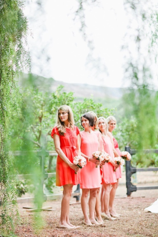 Mismatched bright pink and red bridesmaid dresses plus nude heels for a stylish spring or summer wedding